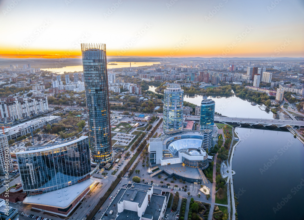 Obraz premium Yekaterinburg city and pond aerial panoramic view at summer or early autumn sunset. Night city in the early autumn or summer.