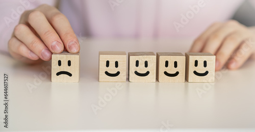 Wooden Level of mental health assessment max positive. cubes blocks with happy and sad face smile face symbol on pink background