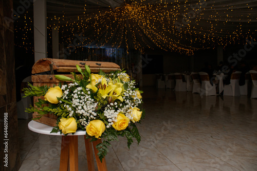 Salón de eventos decorado con flores amarillas, blancas y rosadas photo