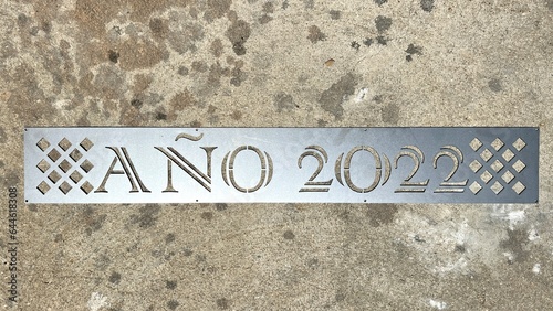 Image of a metal sheet that says year 2022 in Spanish