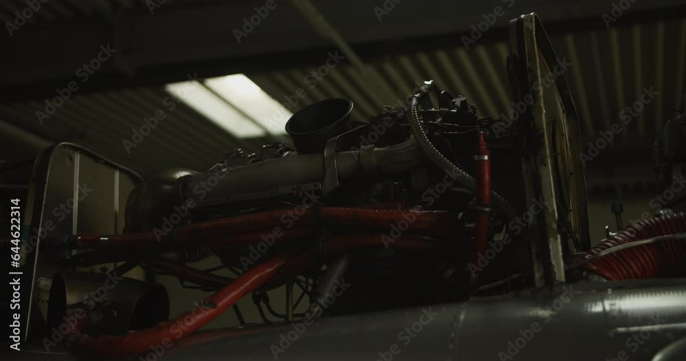 Rack focus of uncovered helicopter engine. Low light scene inside hangar. Airport and aviation concept Rack focus of uncovered helicopter engine. Low light scene inside hangar. Airport and aviation concept