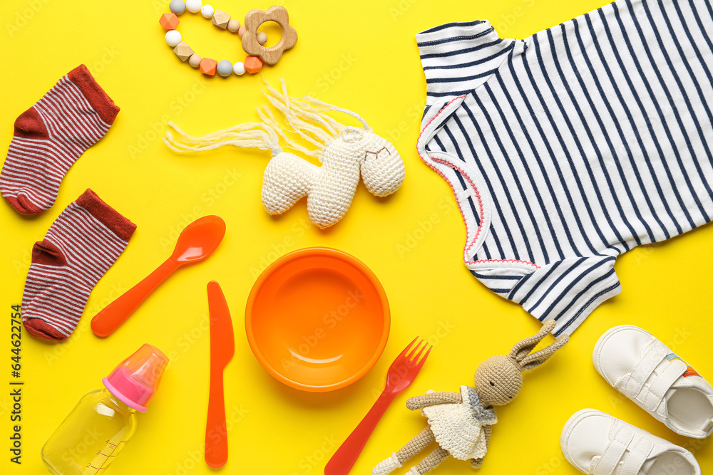 Composition with different baby accessories and clothes on yellow background Composition with different baby accessories and clothes on yellow background