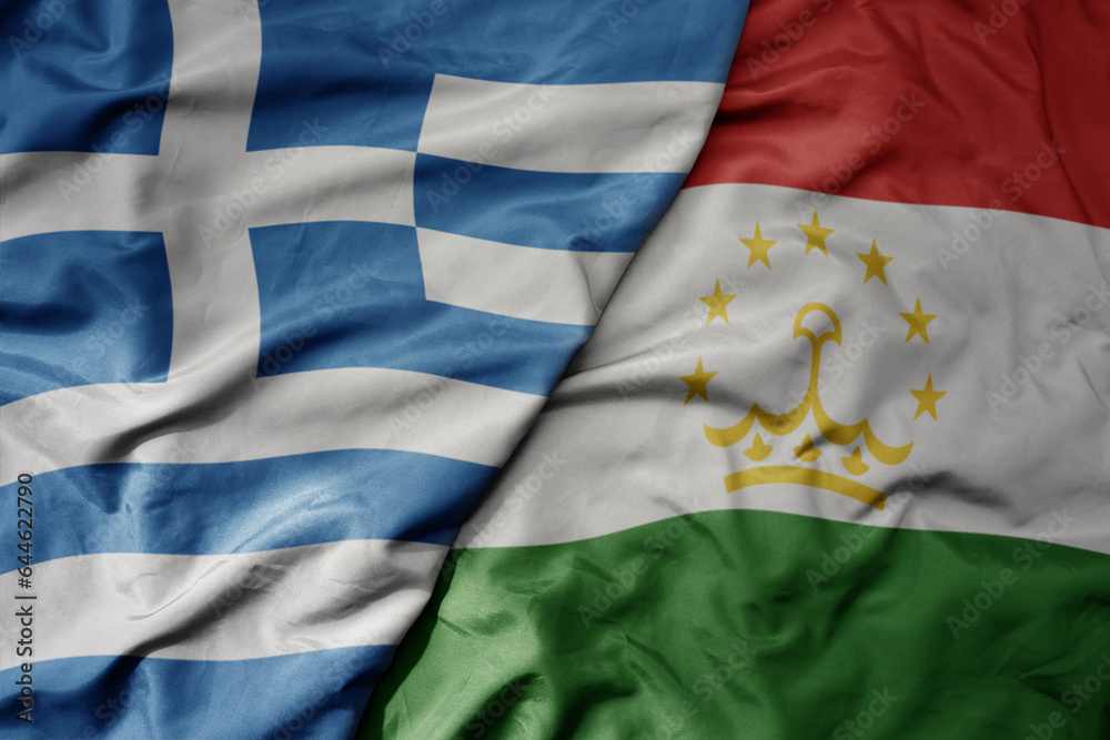 Fototapeta premium big waving national colorful flag of greece and national flag of tajikistan .