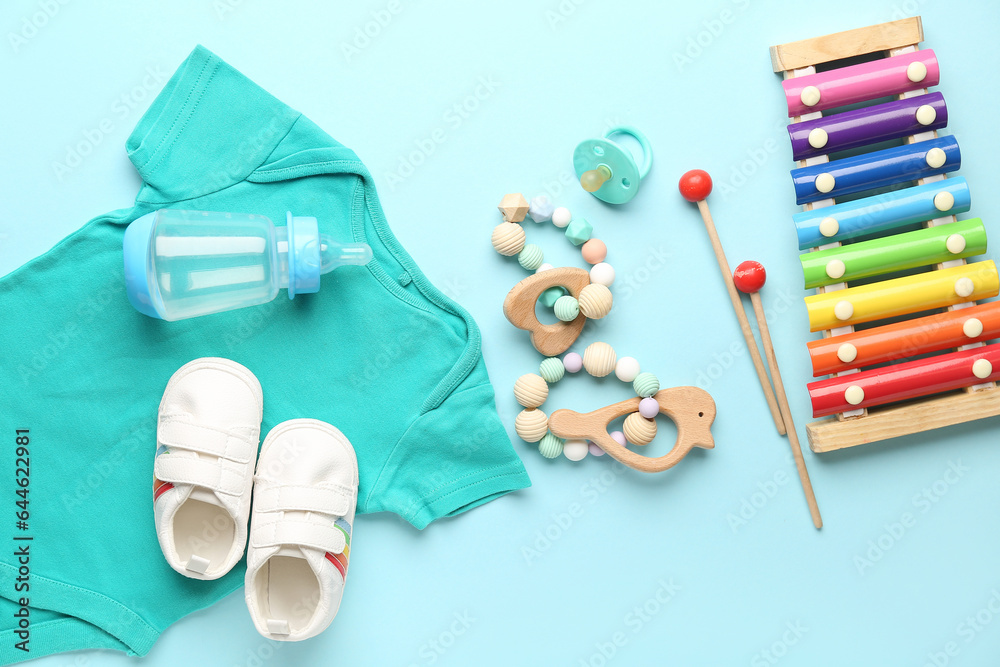 Composition with baby clothes, toys and accessories on color background