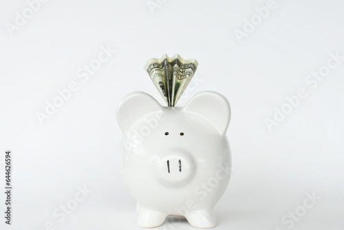 Ceramic Piggy Bank $100 bill folded in top. Concept saving money cash currency. White background
