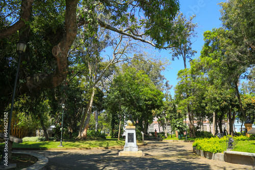 San José, Costa Rica, Details of the Parque España with statue of Isabella the Catholic, and tourists walking.