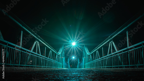 Wroclaw, the Bartoszowicki bridge, a metal structure illuminated at night, enabling crossing to the other bank of the Odra River. photo
