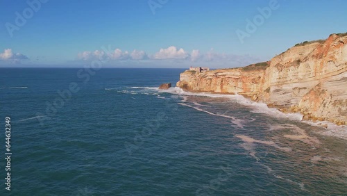 Beautiful aerial view on the rock with the lighthouse from Nazare Beach. Portugal