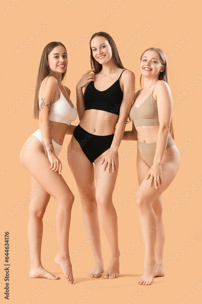 Beautiful women in underwear on beige background