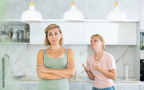 Portrait of upset disappointed woman with teenage daughter calming her, asking to forgive after argument ..