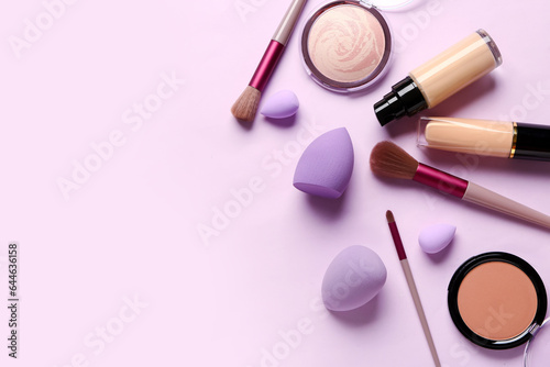 Composition with makeup accessories and cosmetics on lilac background