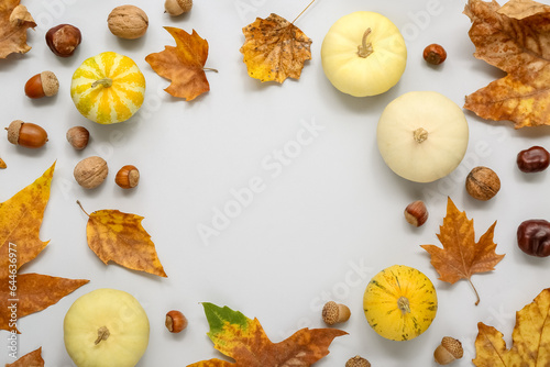 Frame made of pumpkins with acorns and leaves on grey background