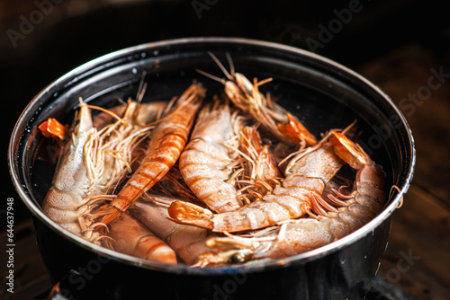 Cooking large king prawns in a saucepan. Boiled red shrimp.