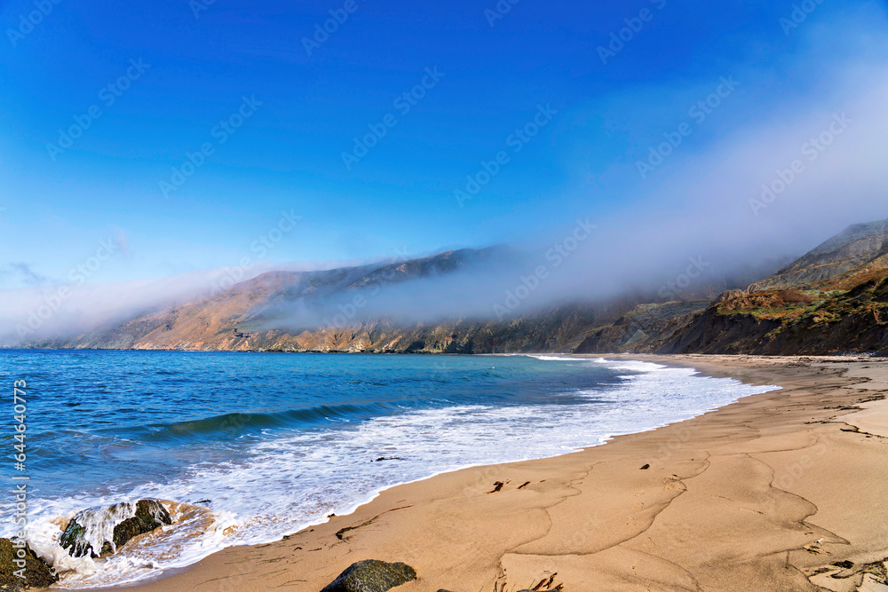Beach and ocean with fog, mountains