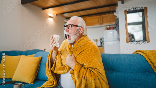 one senior man sit on sofa bed hold Paper tissue common cold sneezing