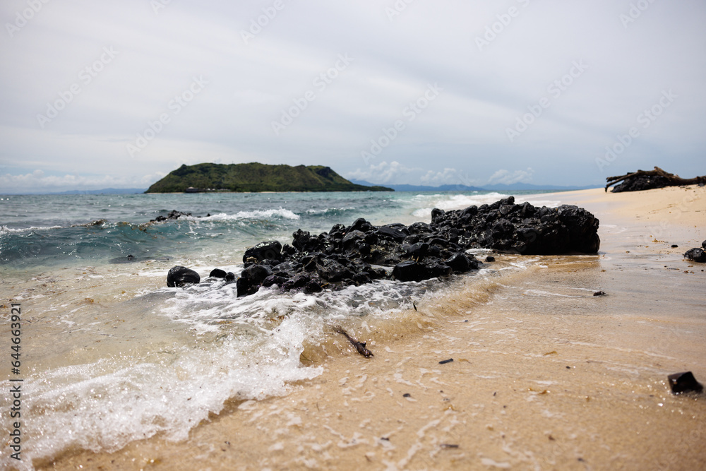surf washing over rocks overlooking vomo island, fiji