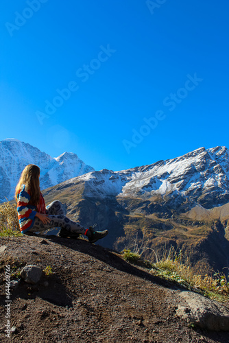 A tourist girl stands on the cliff edge of plateau against mount Elbrus, Russia © Tatiana Kashko