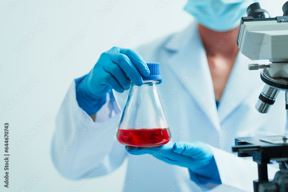 Close up dedicated hematology lab technician scrutinizing blood sample analysis under microscope, scientific laboratory research and drug testing concept, red color liquid Close up dedicated hematology lab technician scrutinizing blood sample analysis under microscope, scientific laboratory research and drug testing concept, red color liquid