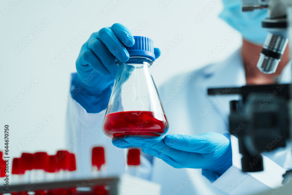 Close up dedicated hematology lab technician scrutinizing blood sample analysis under microscope, scientific laboratory research and drug testing concept, red color liquid Close up dedicated hematology lab technician scrutinizing blood sample analysis under microscope, scientific laboratory research and drug testing concept, red color liquid