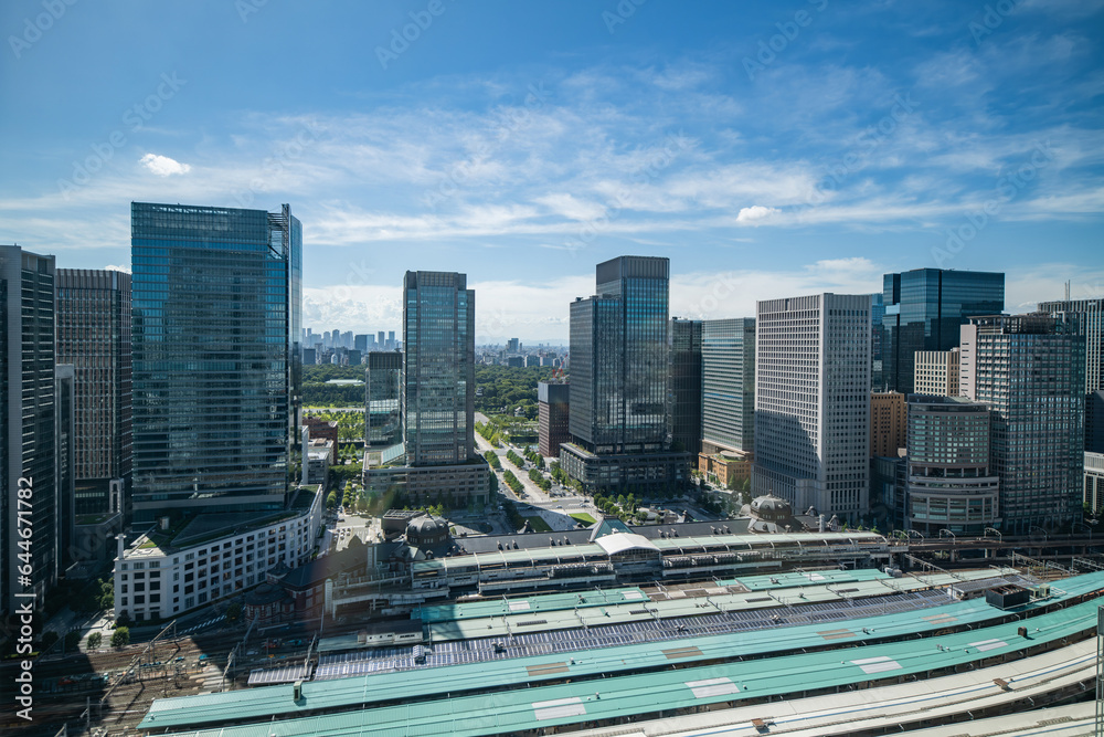 exterior view of Tokyo station from above he tracks in Tokyo, Japan on a sunny and partly cloudy day with skyscrapers in the background along with the Tokyo skyline exterior view of Tokyo station from above he tracks in Tokyo, Japan on a sunny and partly cloudy day with skyscrapers in the background along with the Tokyo skyline