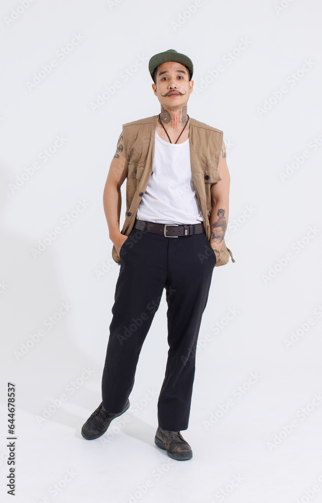 Portrait isolated cutout studio full body shot Asian vintage classy mustache neck arms tattoos male fashion model in casual fashionable safari vest and cap standing look at camera on white background