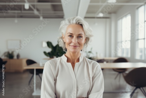 Smiling portrait of a happy senior woman working for a startup company in an office