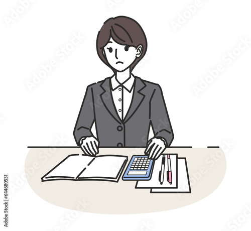 電卓で計算するスーツを着た女性