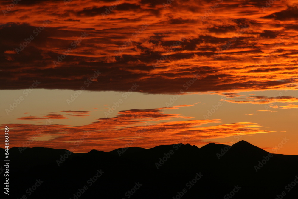 Vibrant Sunset Casting a Silhouetted Mountain Landscape
