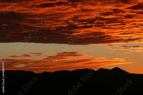 Vibrant Sunset Casting a Silhouetted Mountain Landscape