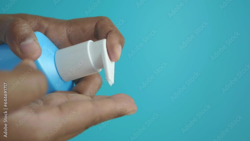 young man pouring moisturizing cream from a container young man pouring moisturizing cream from a container
