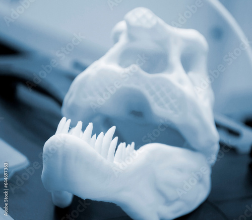 Art object printed on 3D printer. Prototype dinosaur skull head with teeth. Model printed on 3D printer from melted plastic. Object printed close-up. Concept new modern innovation printing technology