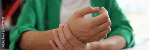 Woman office worker touching sore wrist from using computer