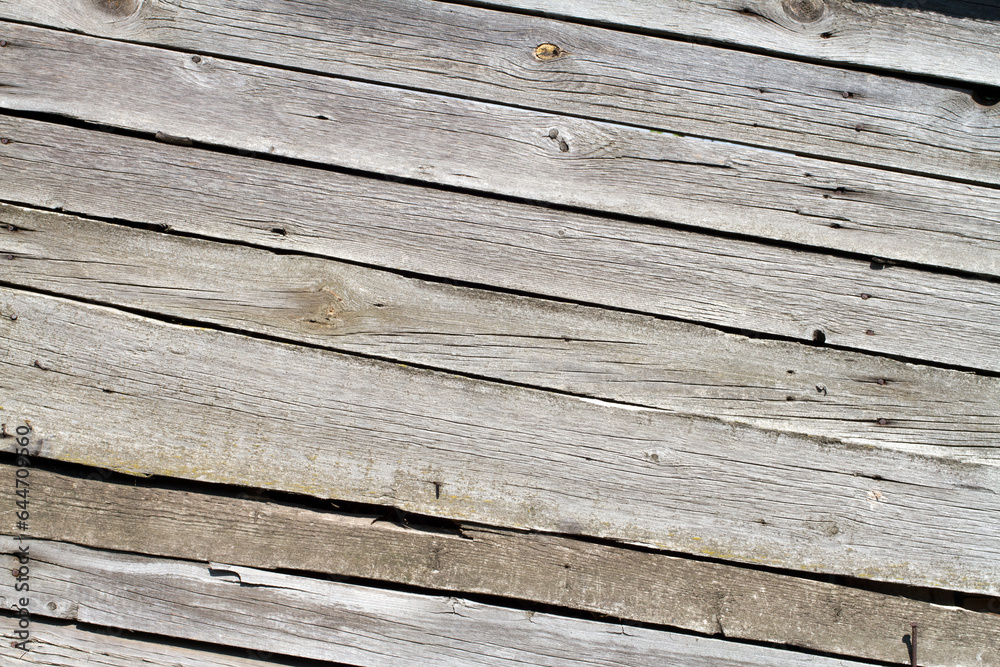 The texture of old wooden planks arranged diagonally. Gray wooden boards. Background texture. The texture of old wooden planks arranged diagonally. Gray wooden boards. Background texture.
