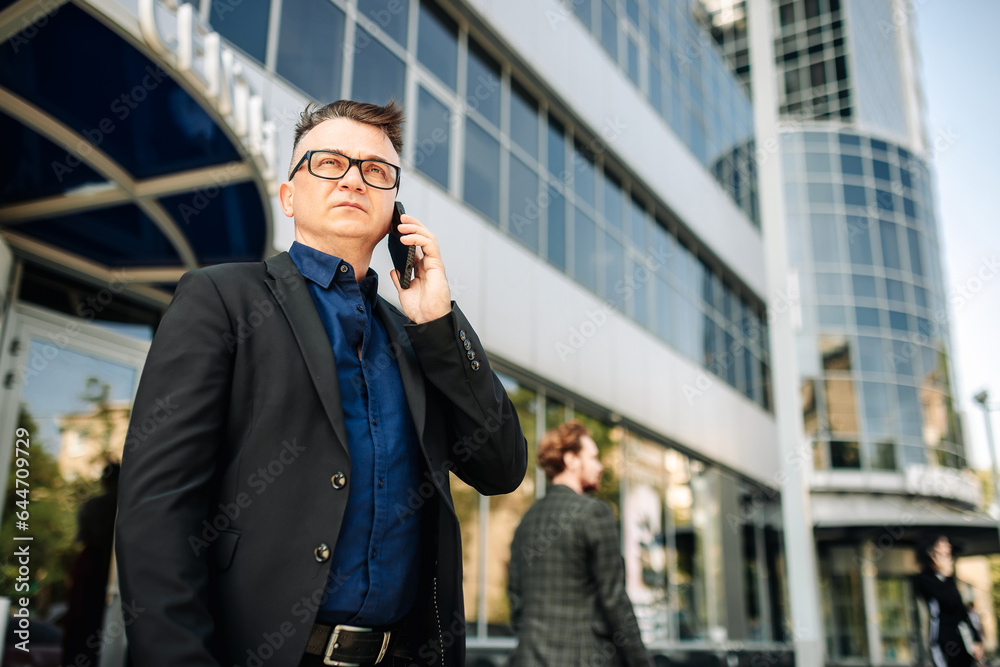 Closeup happy handsome male businessman successful on the city street. Portrait of a successful man outdoors. Modern gadgets for lifestyle. Closeup happy handsome male businessman successful on the city street. Portrait of a successful man outdoors. Modern gadgets for lifestyle.