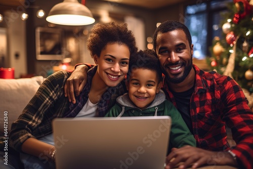 happy african american traditional family making a video call at christmas, parents and son smiling looking to the camera