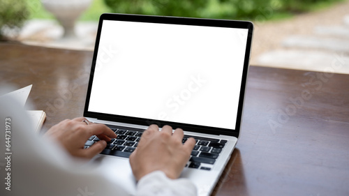 Close-up image of a female freelancer using her laptop computer at a table in a cafe.