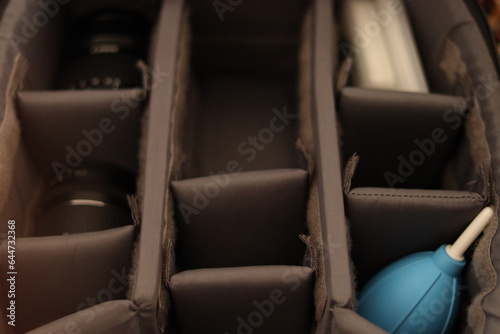Compartments of DSLR Camera with lenses , Camera filter cases and Camera Cleaning Kit with selective focus 