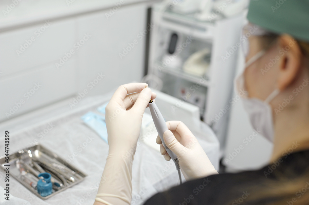 hands of doctor hold key nozzle and piezoelectric scaler removal of