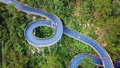 Aerial drone shot of curved Kart Race Track in theme Park, Tonglu, China. race car circuit on sunny day on the mountain. Karting racing sport concept shot.