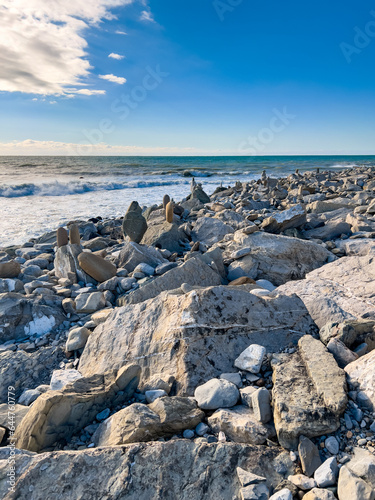 Ocean water splash on rock beach with beautiful sunset sky and clouds. Sea wave splashing on stone at sea shore