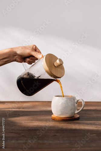 serving french press coffee in a cup, in the morning