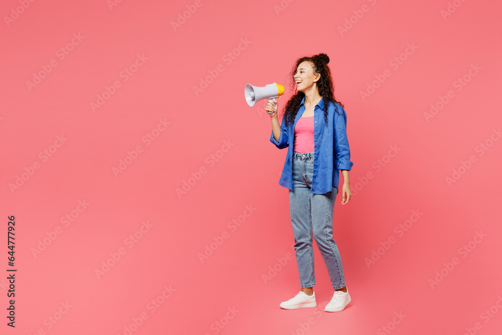 Full body young woman of African American ethnicity she wear blue shirt casual clothes hold in hand megaphone scream announces discounts sale Hurry up isolated on plain pastel pink background studio. Full body young woman of African American ethnicity she wear blue shirt casual clothes hold in hand megaphone scream announces discounts sale Hurry up isolated on plain pastel pink background studio.