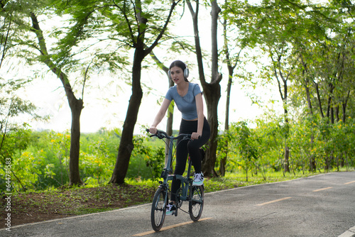 Woman riding a bicycle in the park. Healthy lifestyle and sport concept.