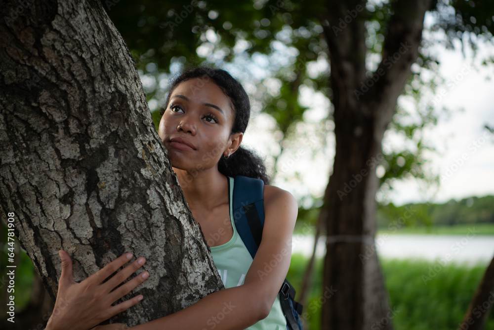 Portrait of a beautiful young woman with backpack standing and forest bathing Portrait of a beautiful young woman with backpack standing and forest bathing