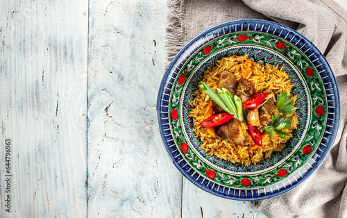 uzbek hot dish of boiled rice, chicken meat, vegetables and spices pilaf in plate with oriental ornament, banner, menu, recipe place for text, top view