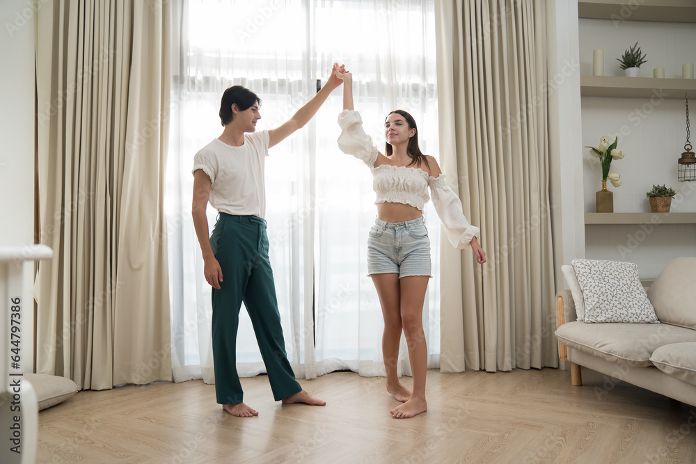 Young male and female couple dancing together with happy and smiling at home