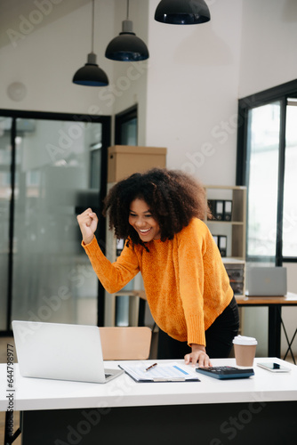 Vászonkép African business woman are delighted and happy with the work they do on their tablet, laptop and taking notes at the office