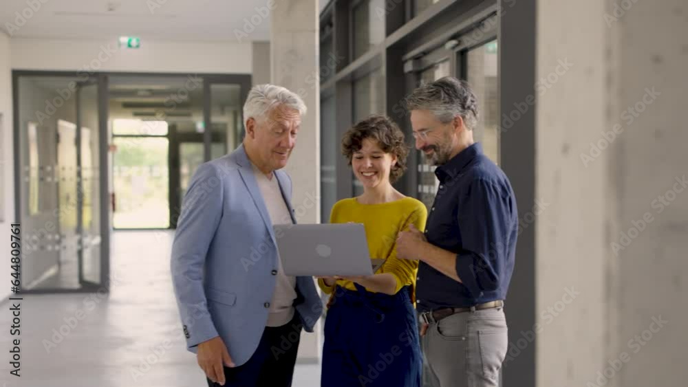 Young professional showing presentation on laptop to senior colleagues Young professional showing presentation on laptop to senior colleagues