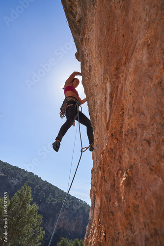Female alpinist hanging off cliff