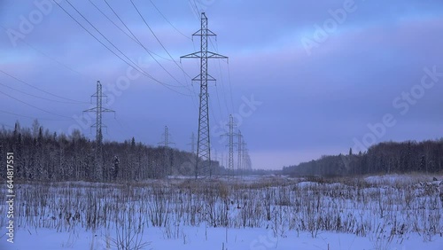 Power transmission line (electricity pylons) at the winter forest edge